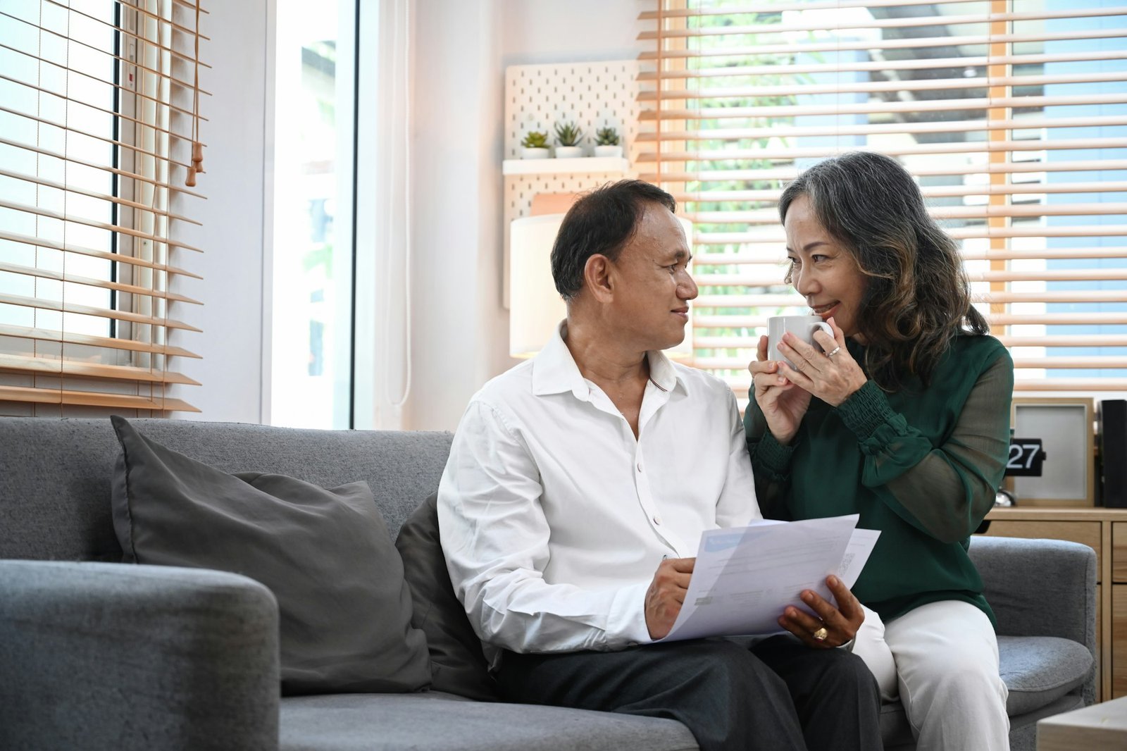 Happy senior couple relaxing on couch, spending time together in cozy living room.